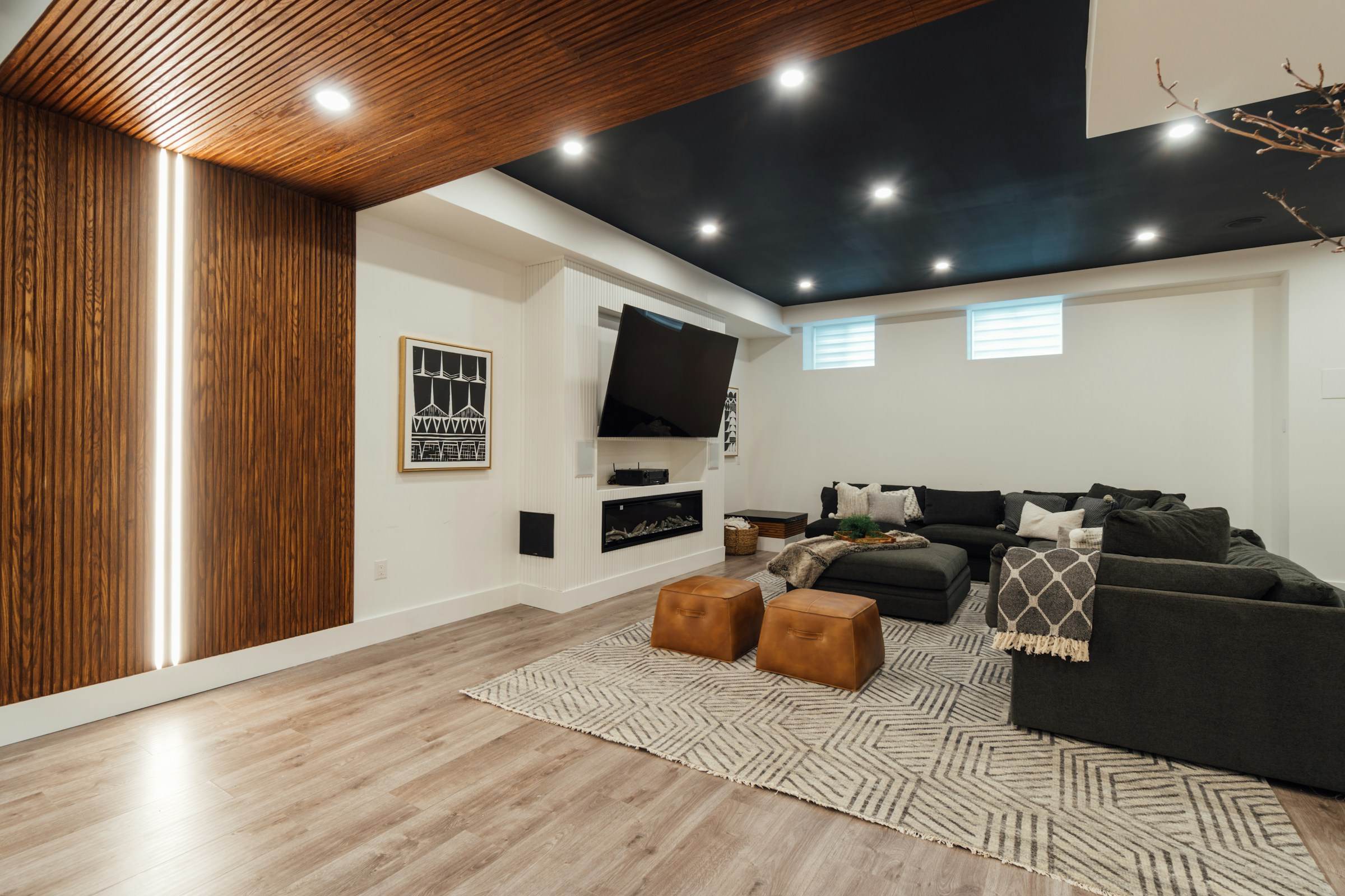 Finished basement media room with slatted timber wall, LED lighting and dark ceiling