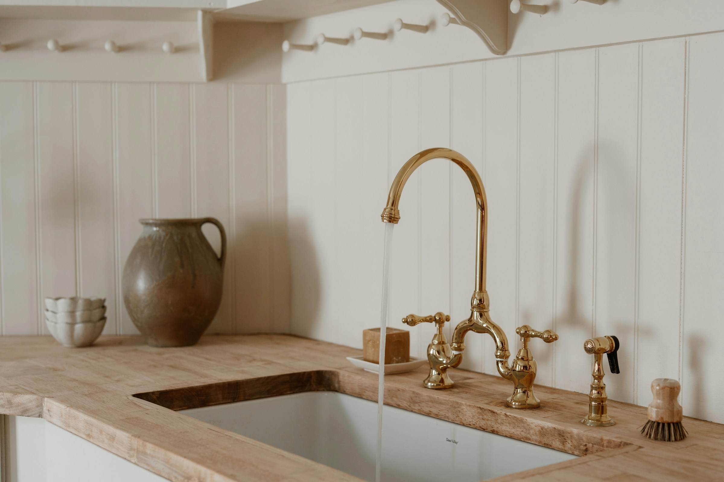 Brass bridge tap over an undermount sink with a timber worktop