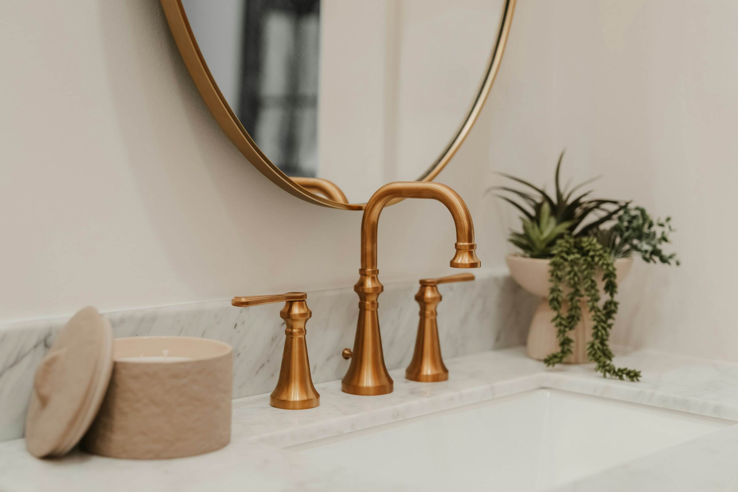 Brushed brass tap set on a marble vanity top