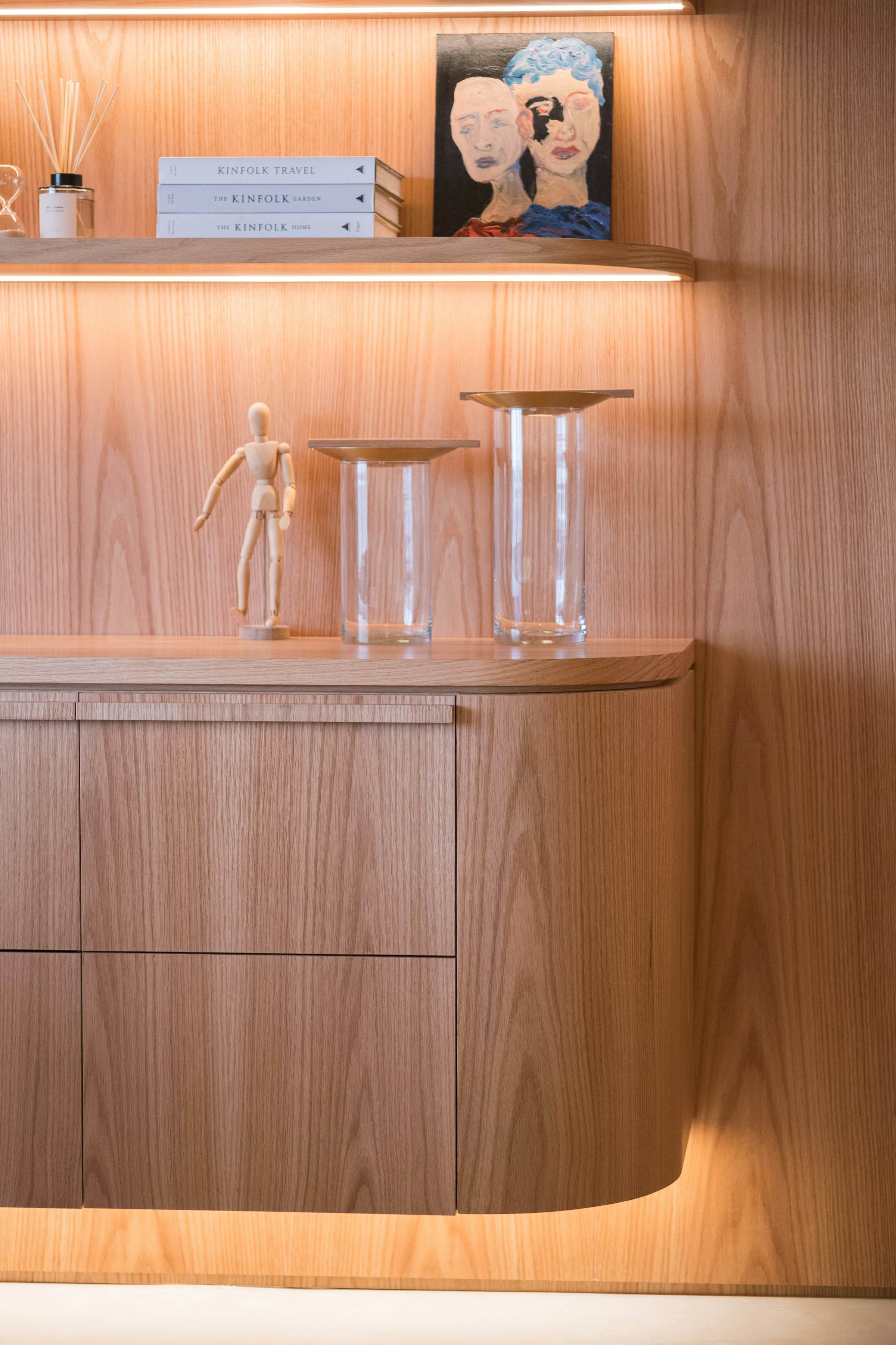 Curved oak joinery with integrated shelf lighting
