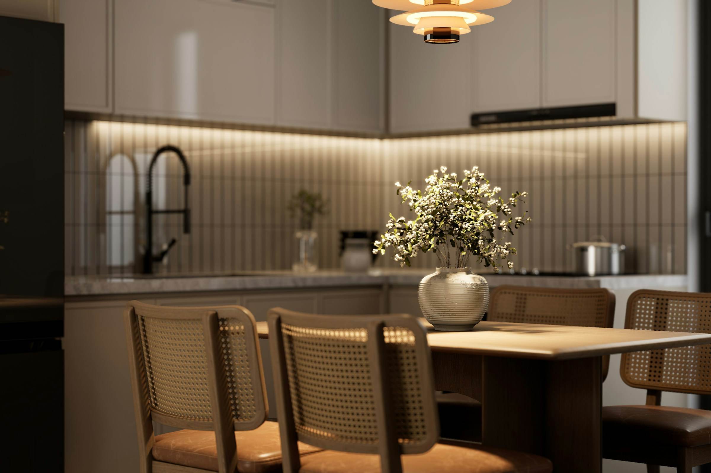 Kitchen and dining area in the evening, lit by under-cabinet lighting and a pendant